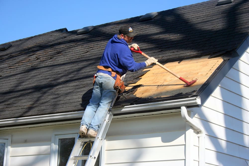 Roofer working from a ladder at the roof edge