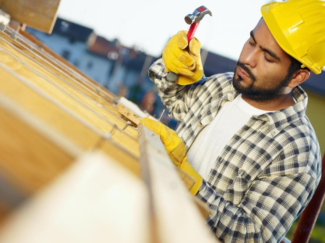 Roofer working at a fascia and roof edge