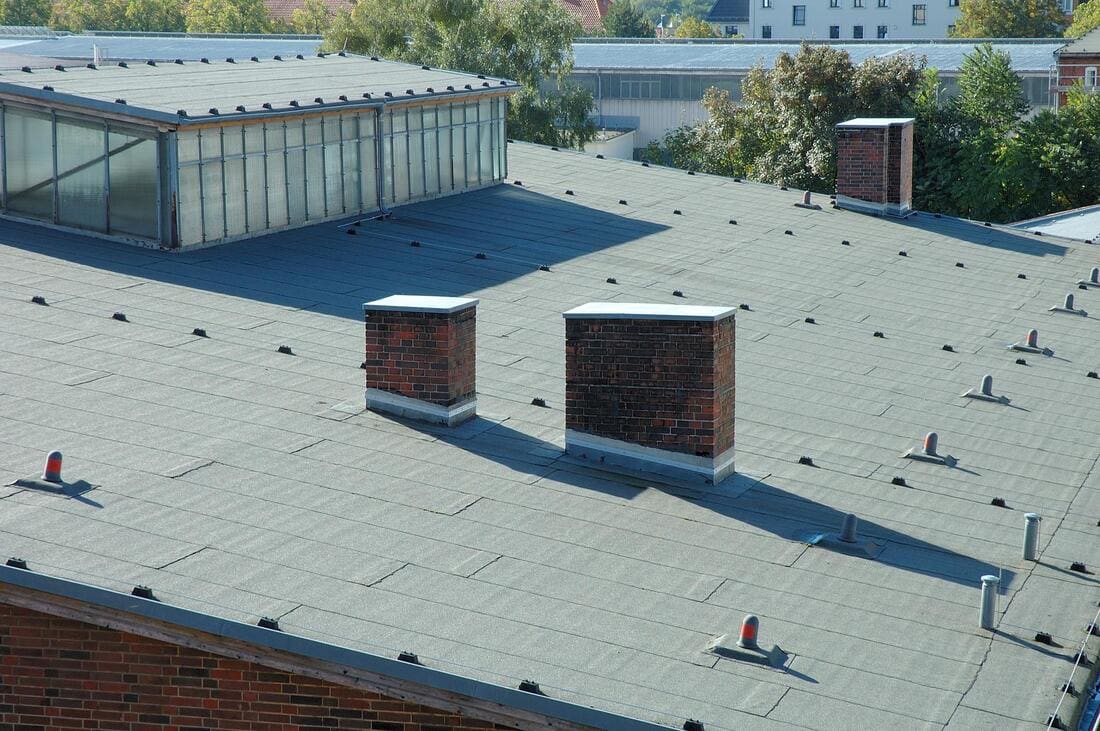 Low-slope roof overview with chimneys